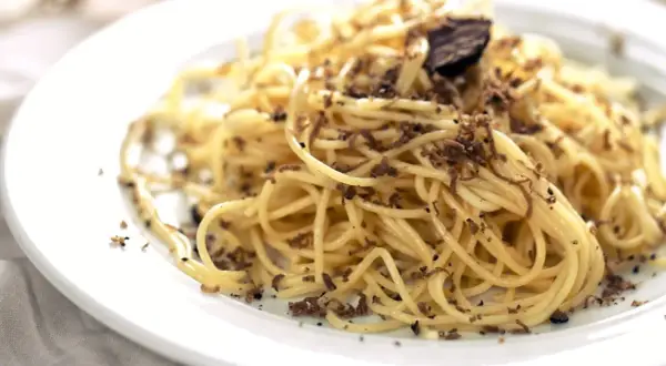 En tallrik med spaghetti, generöst toppad med finriven tryffel. Perfekt för en lyxig middag med ett gott vin till tryffelpasta.
