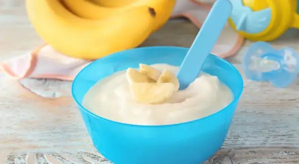 Semolino alla banana in ciotola blu, pronto per essere gustato. Ecco come si fa il semolino per i più piccoli!