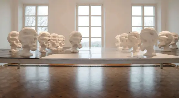 Rzędy białych, ekspresyjnych głów, dzieło Wandy Czełkowskiej, tworzą niepokojącą instalację w galerii.