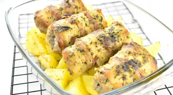 Roladki schabowe z piekarnika, zawinięte w boczek i posypane ziołami, pieczone z ziemniakami.