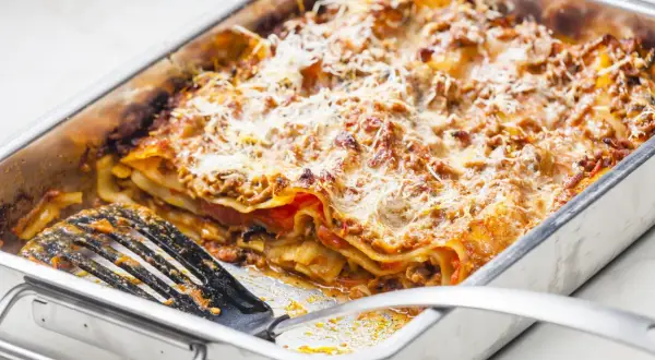 Lasagnes généreuses dans un plat, prêtes à servir. Une quantité parfaite pour régaler 12 personnes.