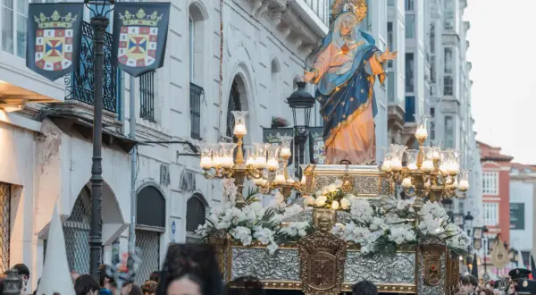 Procesión de Semana Santa. La Virgen María, adornada con flores, es llevada en andas. Se pregunta cuándo es la procesión del encuentro.