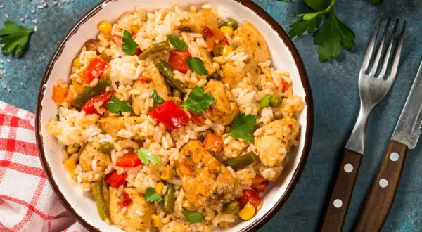 Pyszne risotto z kurczakiem, warzywami i ziołami w misce, gotowe do podania.