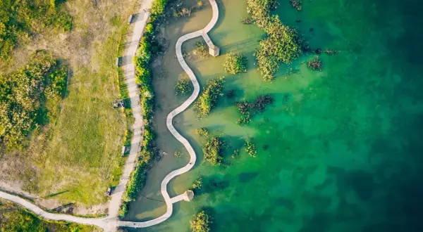 Malownicze polskie Malediwy: kręta kładka wśród turkusowej wody i zieleni.