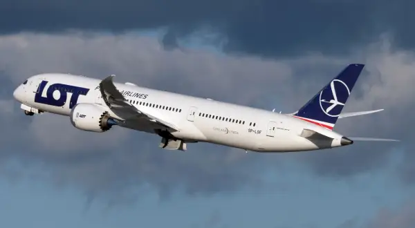 Biały Dreamliner LOT-u wznosi się na tle burzowych chmur. To dumny element polskiej floty lotniczej.