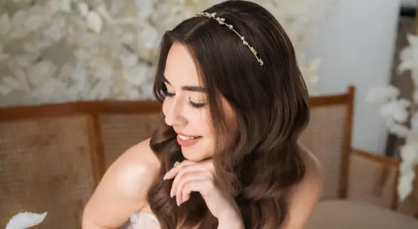 Delikatna tiara ślubna Swarovski zdobi włosy brunetki, dodając blasku jej ślubnej stylizacji.
