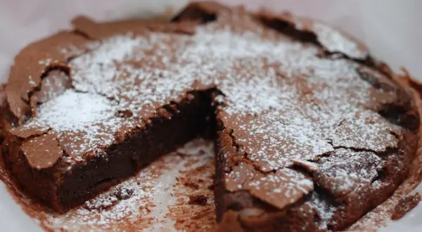En saftig kladdkaka med pudersocker, perfekt för kladdkakans dag.