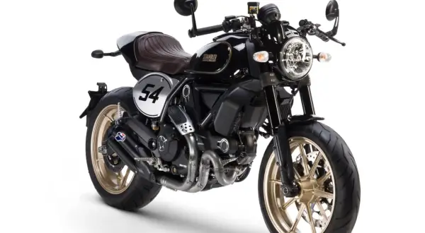 Ducati Scrambler Cafe Racer negra con asiento marrón, llantas doradas y el número 54 en un círculo blanco.