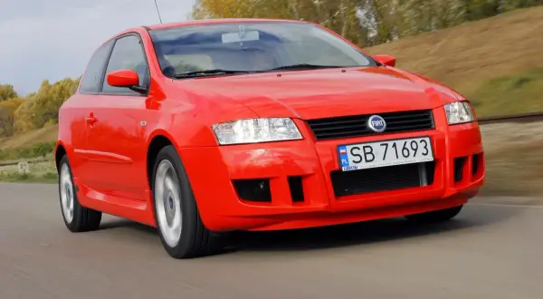 Czerwony Fiat Stilo 1.6 16v w ruchu, z widocznym numerem rejestracyjnym SB 71693.