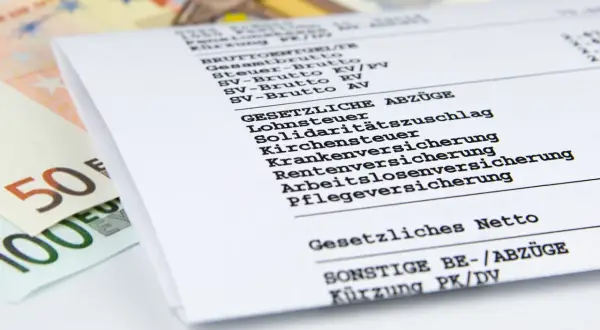 Lohnabrechnung zeigt Brutto und Netto. Ein Anlagenmechaniker fragt sich nach dem anlagenmechaniker gehalt netto. Euroscheine liegen daneben.
