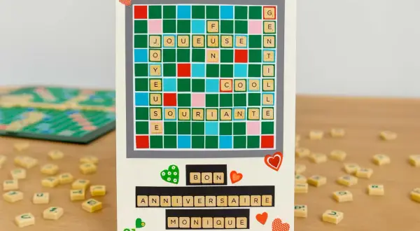 Carte d'anniversaire personnalisée avec un plateau de Scrabble relooké formant "Joyeuse" et "Anniversaire Monique".