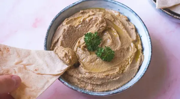 Krämig hummus utan tahini, perfekt att dippa pitabröd i. Garnerad med persilja och olivolja.