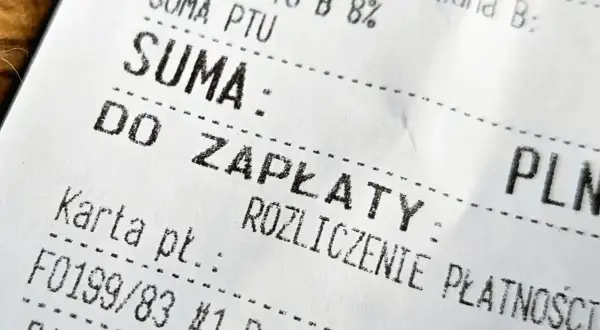 Paragon z nipem, na którym widnieje suma do zapłaty. Karta płatnicza, numer transakcji i nazwisko Paulina.