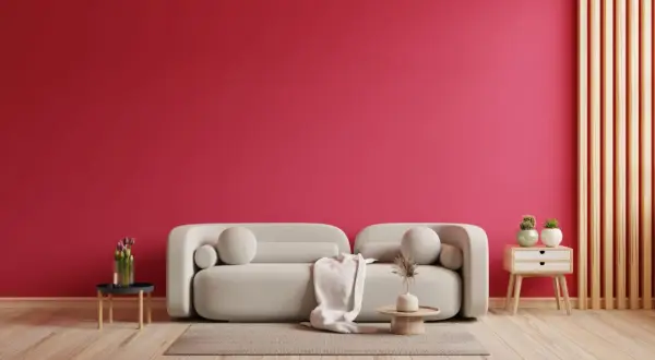 Ściana w kolorze magenta, jak to kolor! Jasna sofa, dywan, stolik z kwiatami i dekoracje.