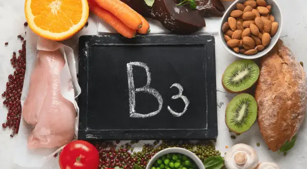 Niacin (B3) ist in Lebensmitteln wie Hühnchen, Leber, Erbsen, Orangen, Karotten, Tomaten, Mandeln und Brot enthalten.
