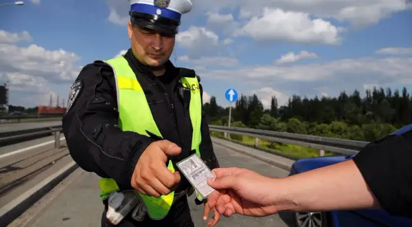 Policjant w kamizelce odblaskowej prosi o okazanie dokumentów. Czy trzeba mieć przy sobie prawo jazdy? Tak, podczas kontroli drogowej.