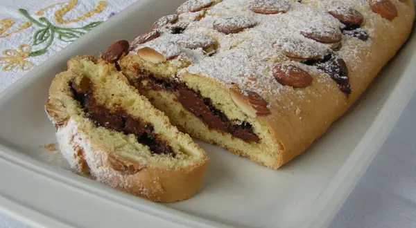 Ciambellone marchigiano con ripieno goloso di Nutella, decorato con mandorle e zucchero a velo.