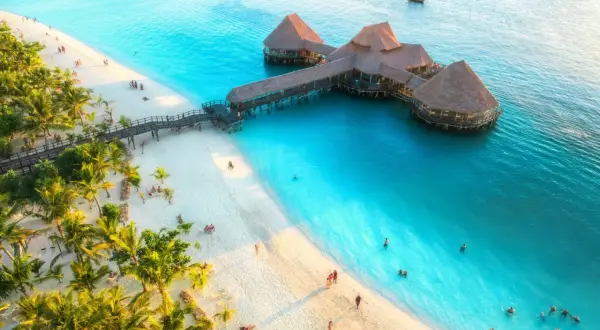 Rajska plaża na Zanzibarze z palmami i restauracją na wodzie. Sprawdź zanzibar ceny i zaplanuj wymarzone wakacje!