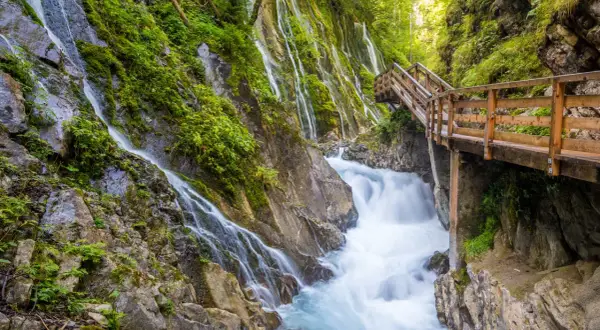 Holzwanderweg führt an rauschenden Wasserfällen vorbei durch die Berchtesgadener Alpen.