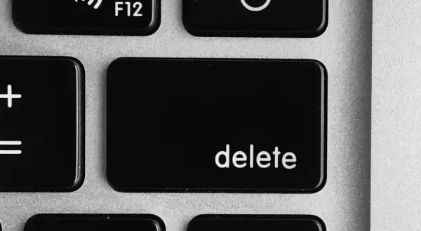 Close-up of a laptop keyboard showing the '+' and '=' keys, and the prominent 'delete' key.