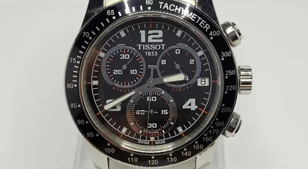 Reloj Tissot 1853 con cronógrafo y cristal de zafiro. Su esfera negra muestra la hora y los sub-diales, con un bisel taquimétrico.