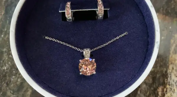 Eleganckie **Swarovski komplety**: naszyjnik z brzoskwiniowym kryształem i kolczyki w pudełku.