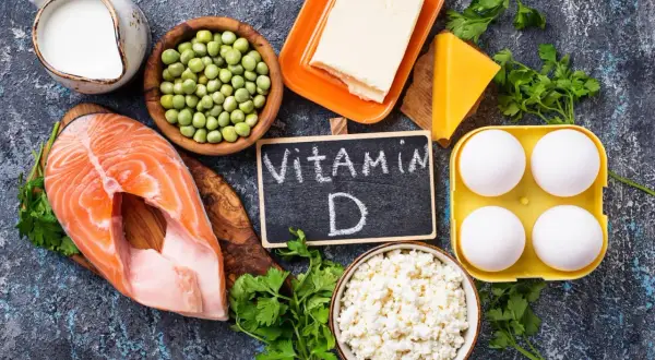 Ingredienti per come prendere la vitamina D: salmone, uova, latte, formaggio, piselli, burro e prezzemolo.