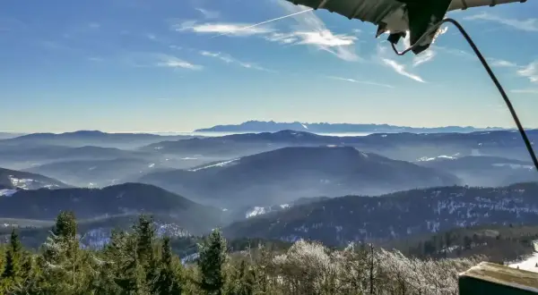 Widok z wieży widokowej na Beskid Wyspowy. W dole las, w oddali pasmo górskie. To najładniejszy szlak na Mogielicę.