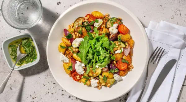 En härlig ugnsrostad grönsaksrätt med potatis, zucchini, tomater och lök, toppad med ricotta och pinjenötter. Ett perfekt ricotta recept för en lätt middag.