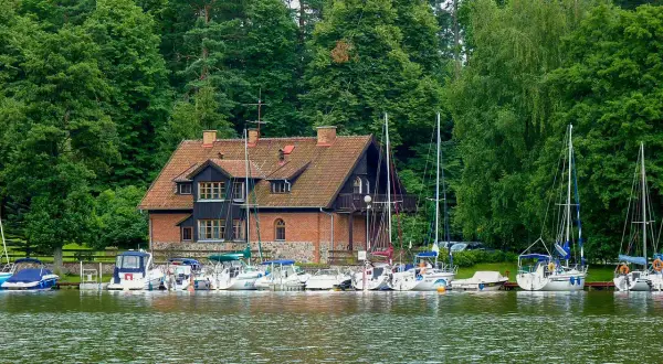 Port w Rucianem Nidzie, z ceglanym budynkiem i żaglówkami, to jedna z głównych atrakcji tego malowniczego miejsca.