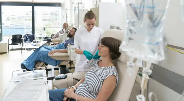 Eine Krankenschwester verbindet eine Patientin mit Infusion. Sie verträgt die chemo gut, ein gutes Zeichen.