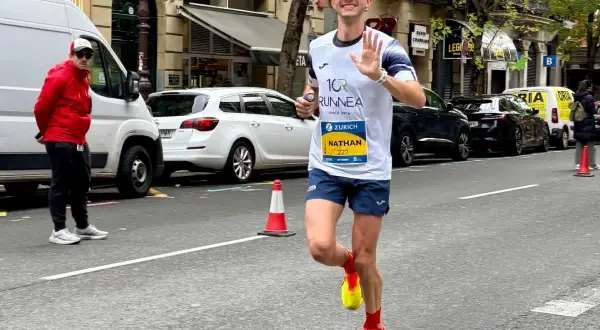 Nathan corre i 10 km in gara, salutando con la mano. Il tempo è ancora da definire, ma la sua energia è palpabile.