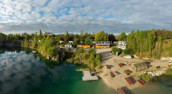 Piękna, piaszczysta plaża nad turkusową wodą, z pomostami i budynkami. Idealne miejsce na wypoczynek.