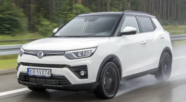 Biały SsangYong Tivoli na mokrej drodze. Wiele osób szuka ssangyong tivoli opinie przed zakupem.