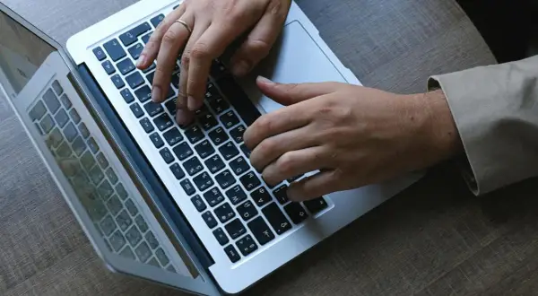 Dłonie piszą na klawiaturze laptopa. W stresującej sytuacji musimy się wszyscy uspokoic i skupić na zadaniu.