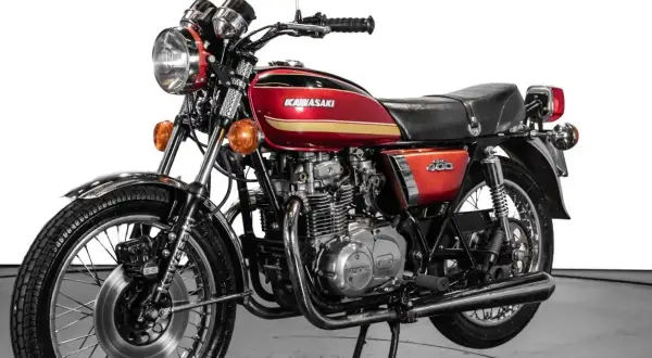 Clásica Kawasaki 400 antigua, roja y dorada, con motor expuesto y detalles cromados. Un icono de los 70.