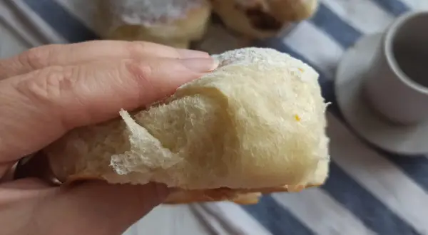 Morbida brioche con lievito madre, cosparsa di zucchero a velo, pronta per essere gustata con un caffè.