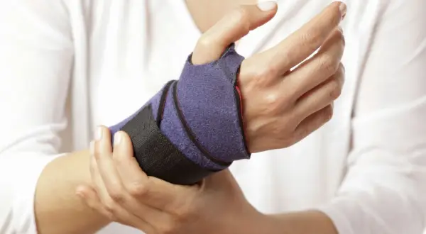 Mano con tutore viola per supportare i movimenti del polso.