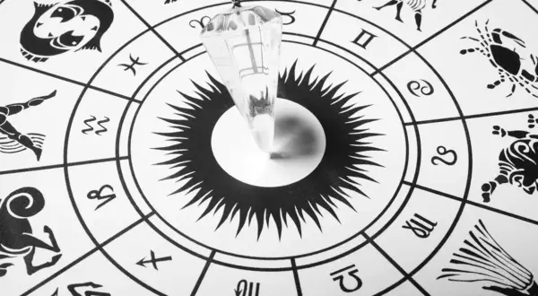 Wahadło nad kołem zodiaku, symbolizujące poszukiwanie odpowiedzi na pytanie: jakim znakiem zodiaku jestem.