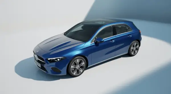 Un elegante Mercedes Clase A W177 azul metálico con techo panorámico, capturado en un estudio con iluminación suave.