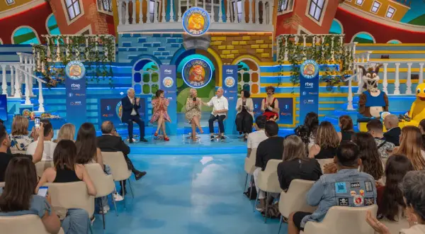 Presentadores y concursantes en el plató del Grand Prix Zaragoza, con un decorado colorido y un público expectante.