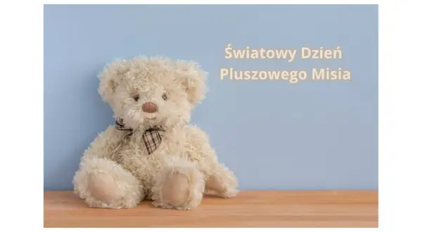 Jasny pluszowy miś z brązową kokardką na jasnoniebieskim tle.