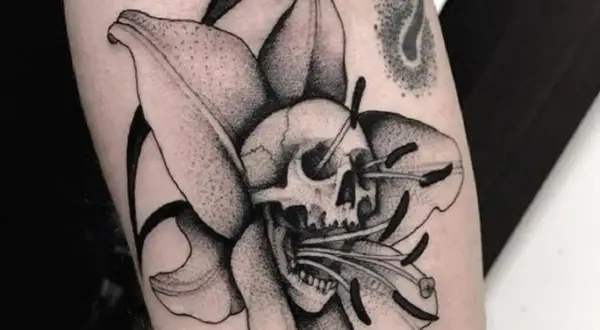 Tatuaże więzienne kropki: czaszka w lilii, symbolizująca przemijanie.