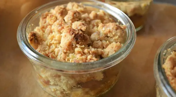Ein köstlicher Apfel Crumble in einem Glas, mit knuspriger Streuseldecke und saftigen Äpfeln darunter.