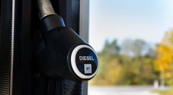 Dystrybutor paliwa z oznaczeniem DIESEL B7, sugerującym zawartość biodiesla. Tło rozmyte, jesienne drzewa.