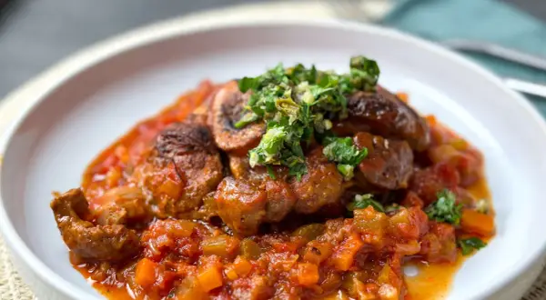 Herzhaftes Ossobuco mit einer reichhaltigen Tomaten-Gemüse-Sauce und frischer Kräuter-Gremolata als Beilage.