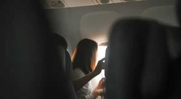 Widok z samolotu. Kobieta przy oknie, pewnie zastanawia się, jaki jest gdańsk antalya czas lotu.