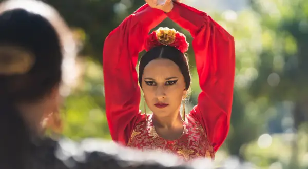Una bailaora de flamenco, con su vestido rojo y sus **manos flamencas** en alto, transmite pasión y arte.