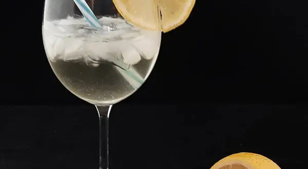 Un verre de spritz saint germain, glacé et garni d'une tranche de citron, prêt à être dégusté.