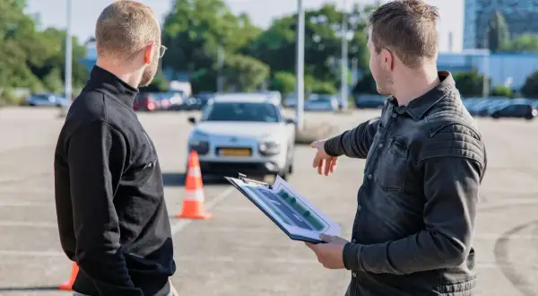 Instruktor omawia trasę egzaminu na kartę motorowerową z kursantem, wskazując na schemat.